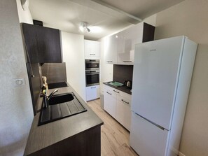 A compact kitchen with a sink, a refrigerator, and built-in ovens. - Sleeps 4, Air conditioning, all on foot (ST MANDRIER SUR MER)