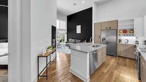 Une cuisine moderne dotée d’un îlot central, d’appareils électroménagers intégrés et d’un coin repas avec un canapé.