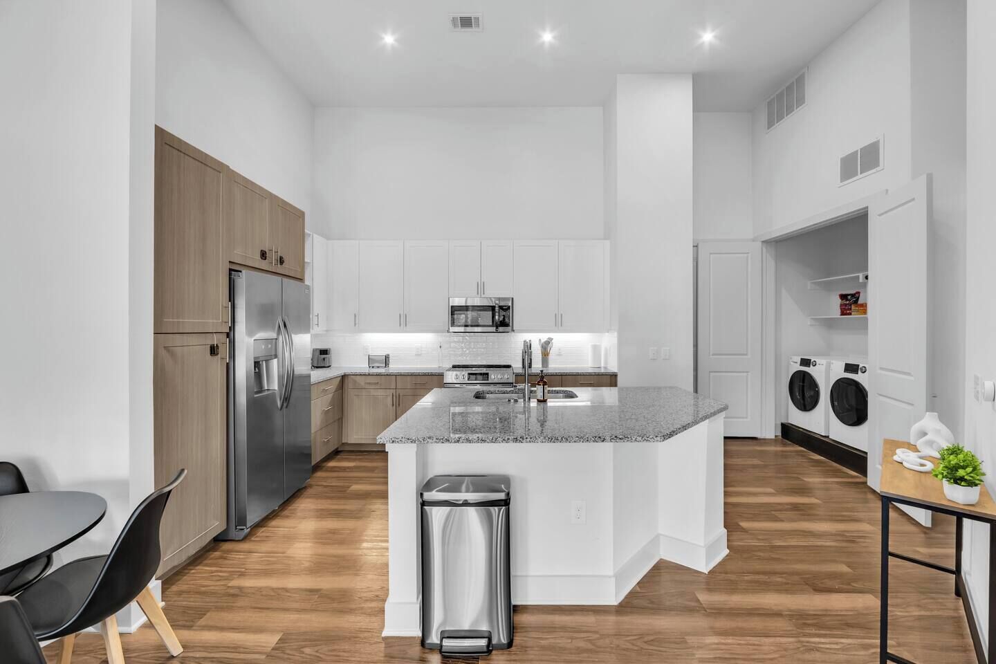A modern kitchen with a central island, stainless steel appliances, and a built-in washing machine.