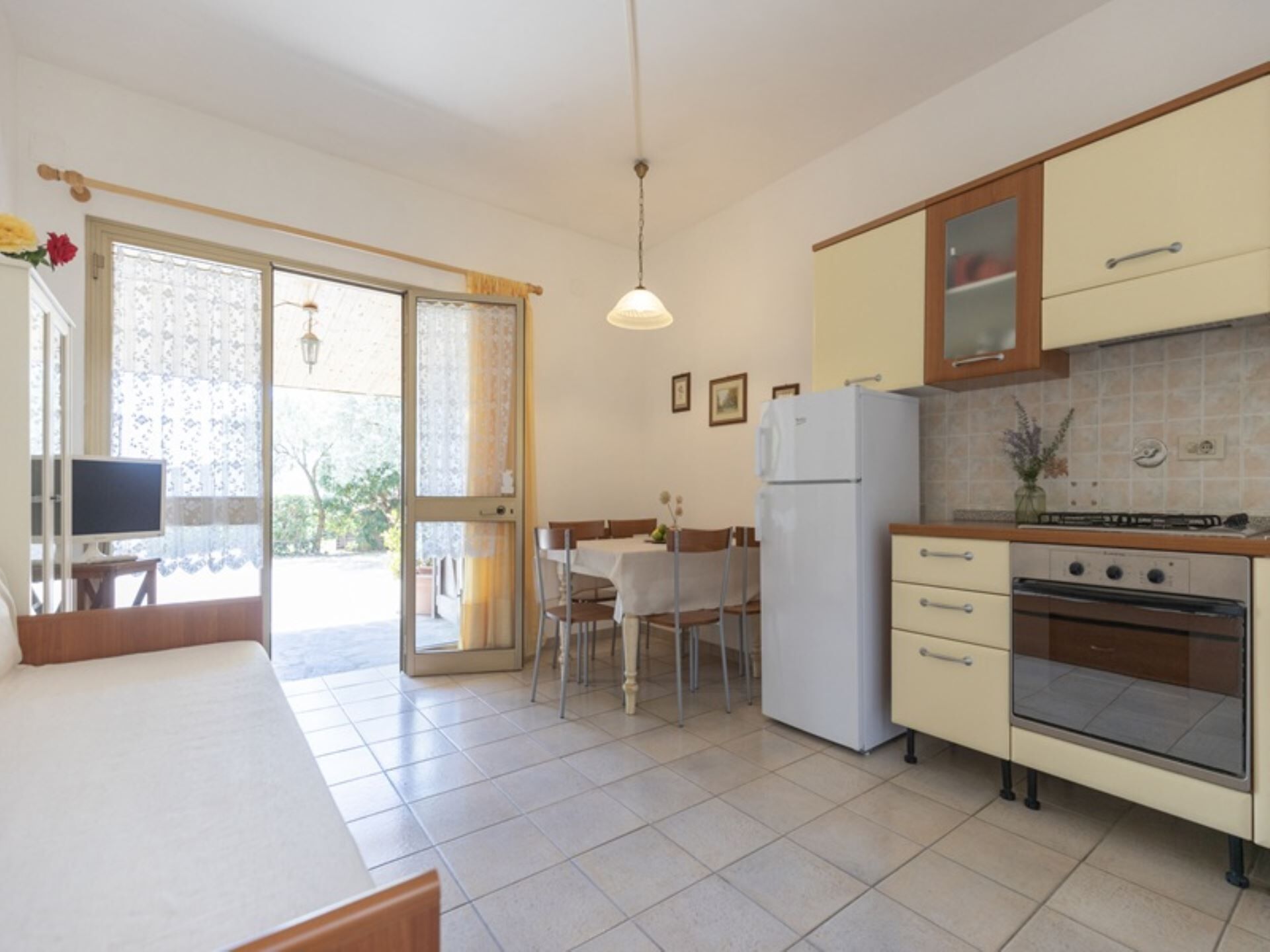 Eine Küche mit Kühlschrank, Backofen und Essbereich mit Stühlen und Tisch.