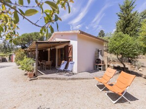 A small house with a patio, two lounge chairs, and a barbecue area. - Belvedere Sea View Country House (Capoliveri)