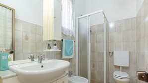 Ein Badezimmer mit Waschbecken, Toilette und Dusche.