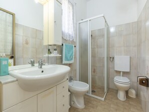 Ein Badezimmer mit Waschbecken, Toilette und Dusche.