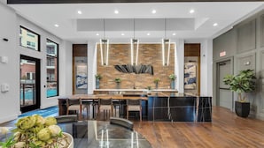 Una cucina moderna con rivestimento in mattoni, luci a sospensione e un'isola centrale.