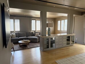 Ein modernes Wohnzimmer mit grauem Sofa, einem Couchtisch und einer Einbaukommode mit Schubladen.