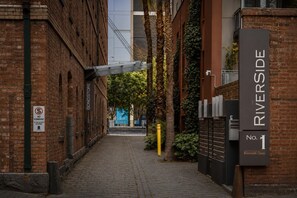 Ein Backsteinhaus mit einem Schild, auf dem 'RIVERSIDE No. 1' und ein 'HALTVERBOT'-Schild steht.