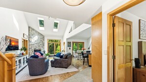 A spacious living area with a stone wall, two sofas, a fireplace, and a dining area.