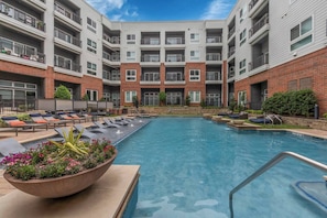 A modern hotel with a central pool, lounge areas, and a brick facade. - FriscoSquare+ToyotaStadium+Pool+Gym+PGAGolf+W+D (Frisco)