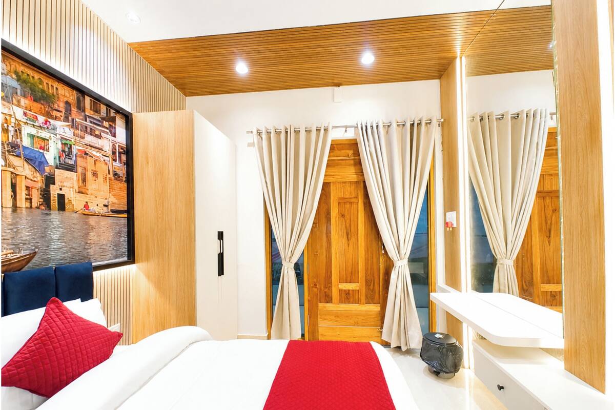 Ein modernes Hotelzimmer mit einem großen Bett, einer Holzzieldecke, einem Stadtbildgemälde und Vorhängen an den Fenstern.