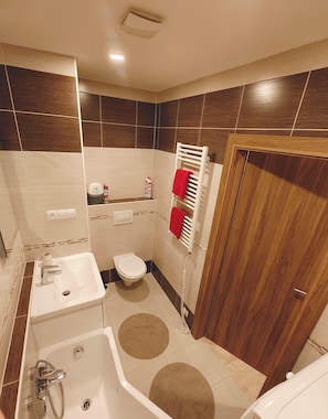 Ein modernes Badezimmer mit Badewanne, Toilette und Waschbecken.