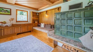 Ein Holzinnenraum mit einer Bank, einem grünen Schrank und einem Fenster mit Blick.