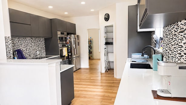 A modern kitchen with a central island, dark cabinetry, and a patterned backsplash. - 5BR Detached Casita with Massive Deck Sleeps 10 in Leander (Leander)
