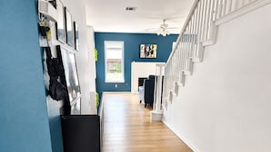 A hallway with a wooden floor, a ceiling fan, and a staircase with white railings. - 5BR Detached Casita with Massive Deck Sleeps 10 in Leander (Leander)