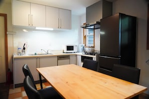A compact kitchen with white cabinets, a black refrigerator, a microwave, and a dishwasher.