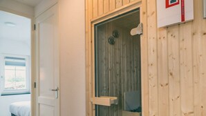 A hotel room with a wooden door, a bed, and a window. - Watervilla Wellness 8 (Medemblik)