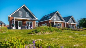 A row of modern houses with attached garages and a grassy lawn. - Watervilla Wellness 8 (Medemblik)
