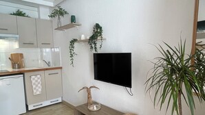 Een moderne keuken met witte kasten, een inbouw vaatwasser en een houten aanrecht.