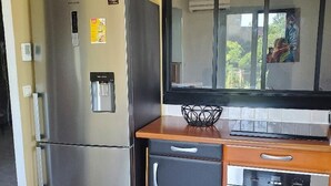 A compact kitchen with a refrigerator, oven, and a microwave. - House with swimming pool, terraces and exceptional views. (Lunas-les-Châteaux)