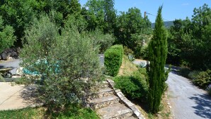 A residential area with a stone staircase leading to a house, surrounded by greenery and trees. - House with swimming pool, terraces and exceptional views. (Lunas-les-Châteaux)