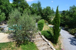 Ein Wohngebiet mit einer Steintreppe, die zu einem Haus führt, umgeben von Grünflächen und Bäumen.