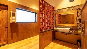 A compact bathroom with a wooden vanity, a sink, and a mirror.