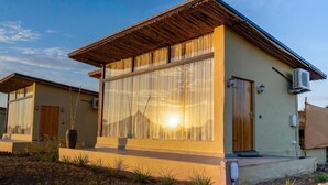 Un edificio moderno con amplios ventanales, techo de madera y unidad de aire acondicionado.