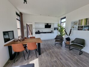 Ein modernes Interieur mit Essbereich, Küche und Sitzgelegenheiten.