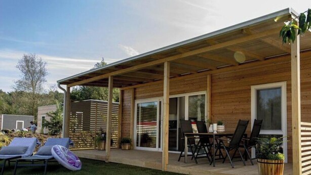A wooden house with a covered patio, a lawn, and outdoor furniture. - Holiday Home in Olburgen With Terrace (Olburgen)