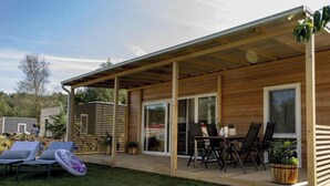 A wooden house with a covered patio, a lawn, and outdoor furniture. - Holiday Home in Olburgen With Terrace (Olburgen)