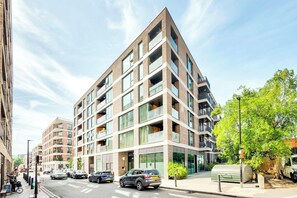 Un edifici residencial de diversos pisos amb balcons, finestres grans i un disseny arquitectònic modern.