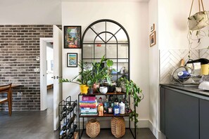 A kitchen with a brick wall, a wine rack, and a mirror. - Modern Flat with Country Charm (London)
