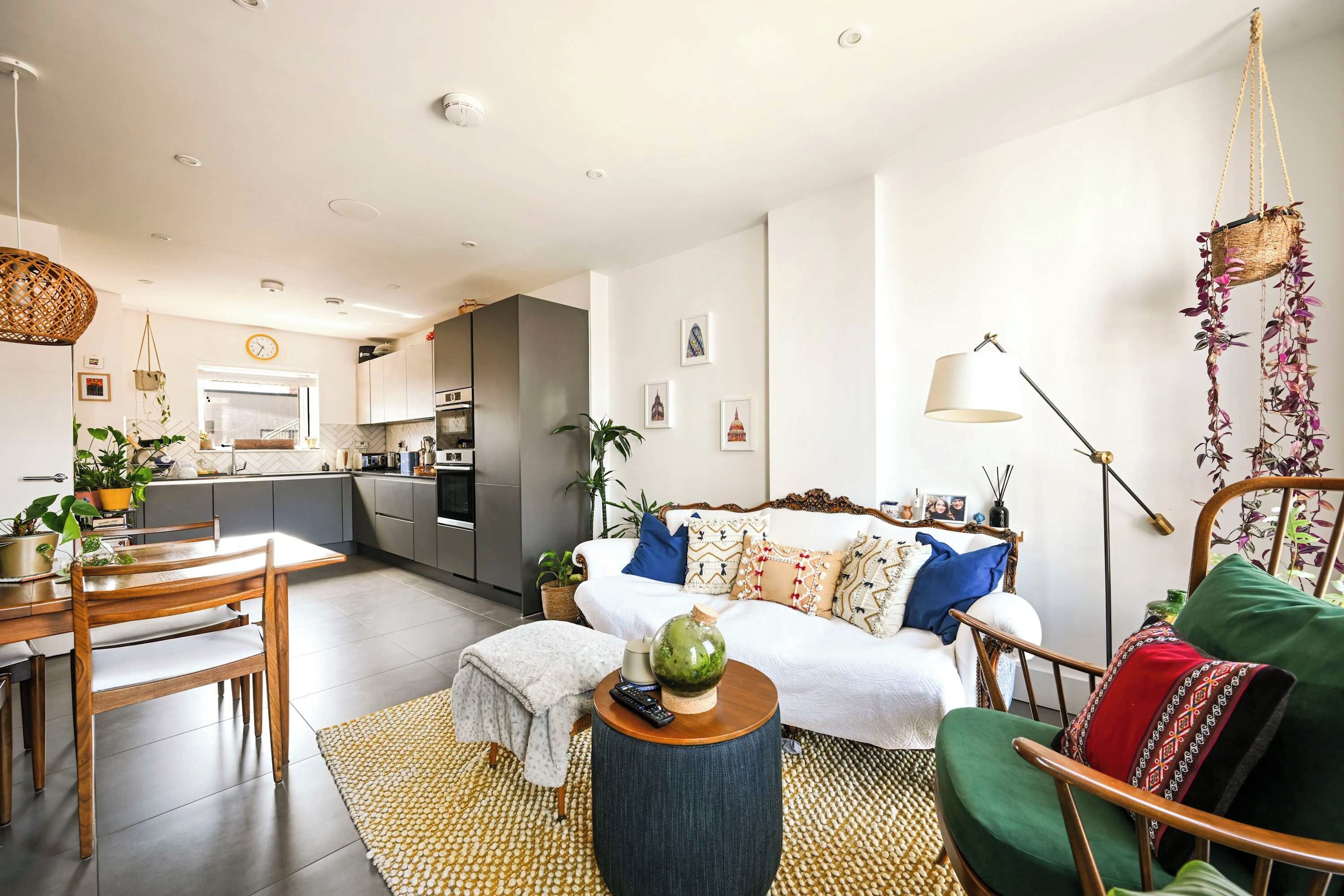 A modern living room with a sofa, coffee table, and dining area.