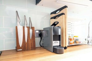 A kitchen with a coffee machine, a knife block, and a cutting board. - The Artist's Studio in Notting Hill (Greater London)