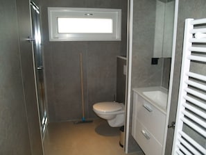 Ein Badezimmer mit Toilette, Dusche und Waschbecken.