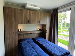Ein Zimmer mit Bett, Deckenventilator und Blick ins Freie.