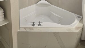 Un baño moderno con una bañera independiente, un estante empotrado y una zona de ducha.