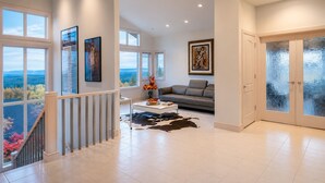 A spacious living area with a sofa, coffee table, and artwork on the walls. - Contemporary Bellevue Home with Panoramic Lake & Mountain Views (Bellevue)