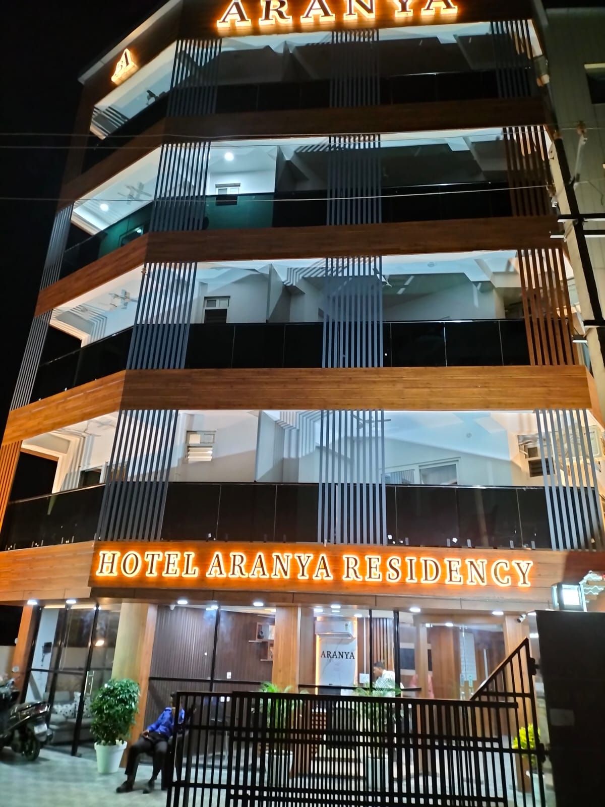 Un edifici de diverses plantes amb un rètol que diu 'Hotel Aranya Residency'.
