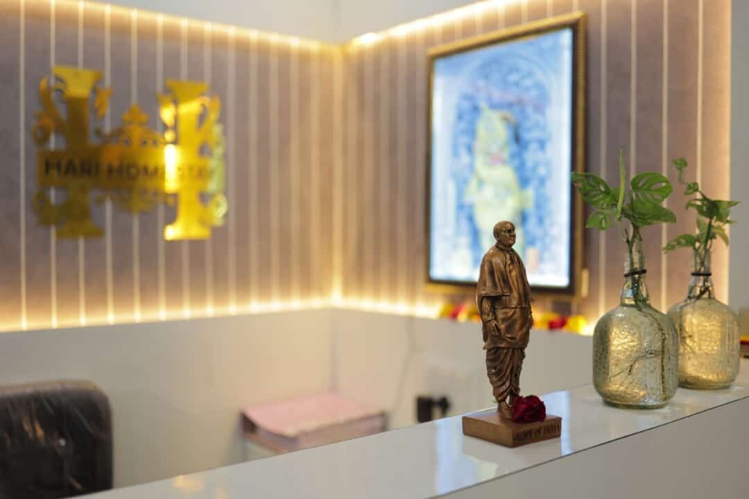 A reception desk with a statue, framed artwork, and decorative bottles.