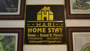 En inramad skylt med texten ”HARI HOME STAY” och kontaktuppgifter till ägaren, Krunal H. Parekh.