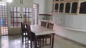 Un comedor con una mesa, sillas, un ventilador de techo y una ventana con vistas.