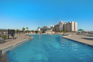 Ein Swimmingpool mit Liegestühlen und einem Gebäude im Hintergrund.