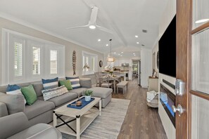 Ein geräumiges Wohnzimmer mit einer Couch, einem Couchtisch und einem Essbereich mit Stühlen und Tisch.