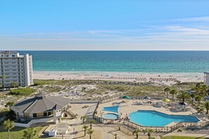 Ein Resort mit Pool, Zugang zum Strand und einem Gebäude mit gewölbtem Dach.