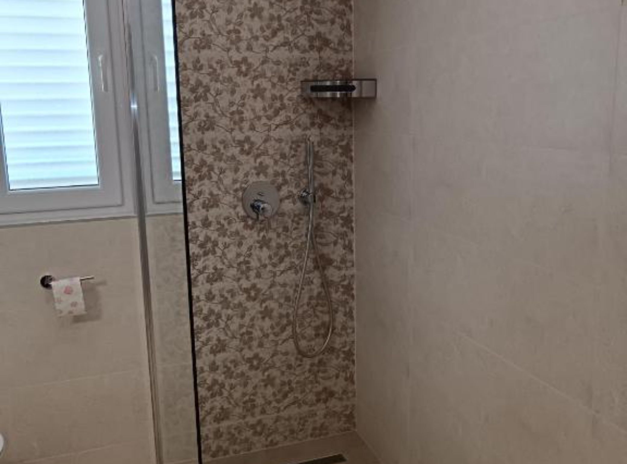 Un baño con ducha, inodoro y ventana.