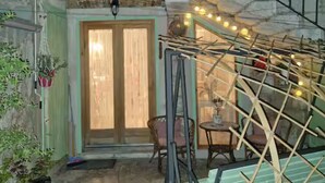 A room with a wooden door, a small table, and a chair. - Diocletian Lux Apartment (Split)