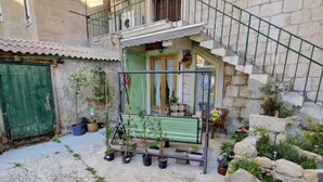 A courtyard with a green bench, potted plants, and a stone staircase. - Diocletian Lux Apartment (Split)