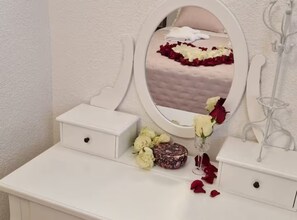 A vanity with a mirror, a small white dresser, and a vase with flowers. - Diocletian Lux Apartment (Split)