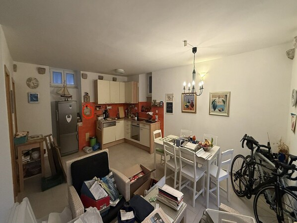 Un espacio habitable compacto con kitchenette, comedor y una bicicleta.