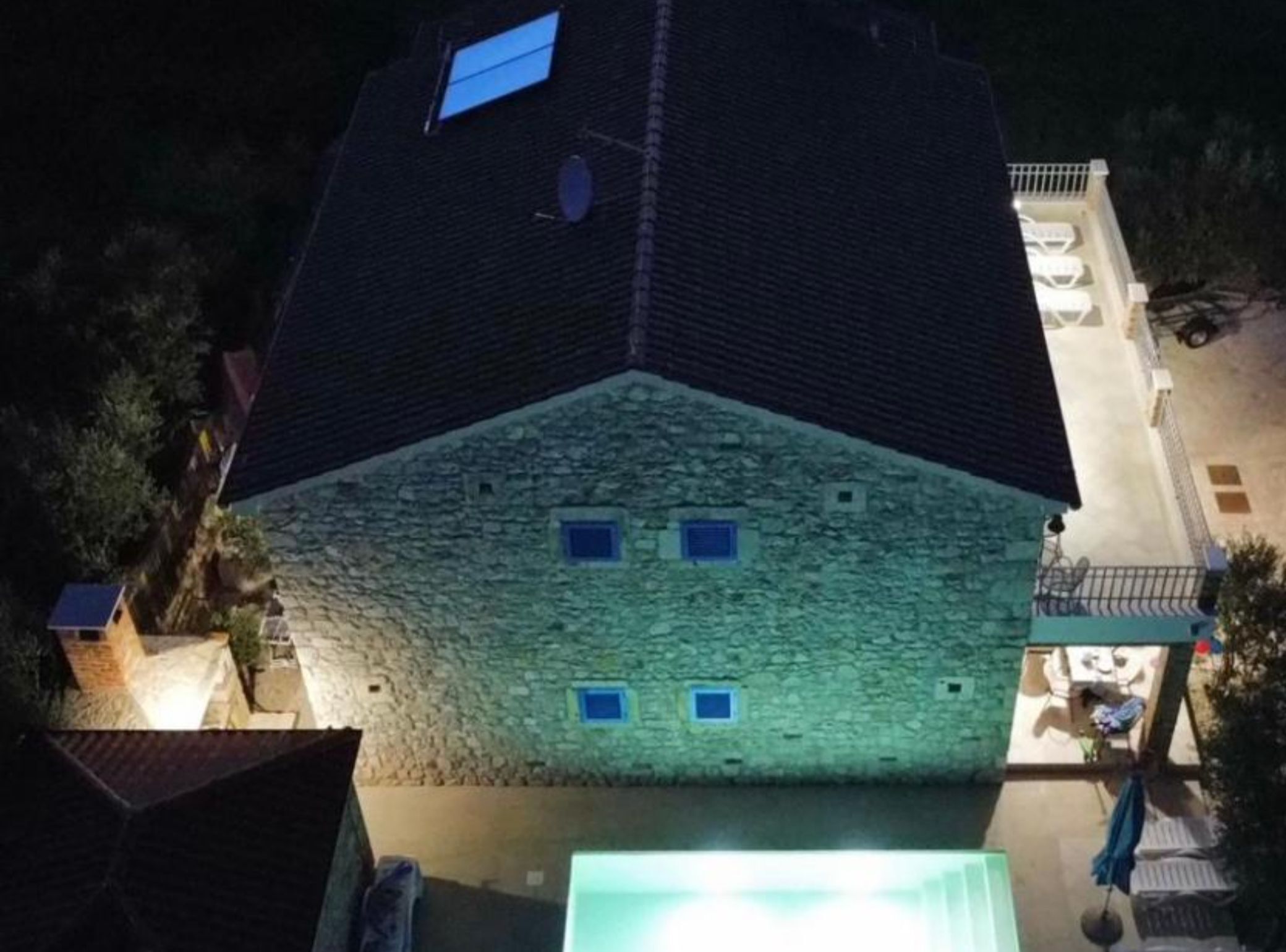 Un bâtiment en pierre avec un toit en pente, de nombreuses fenêtres et un balcon bien visible.